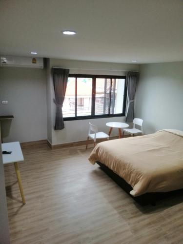 合艾IHome Hatyai的一间卧室配有一张床、一张书桌和一个窗户。