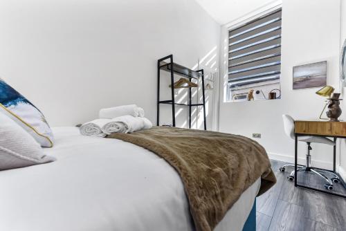 伦敦Comfy and Contemporary One Bedroom Flat的白色的卧室设有床和窗户