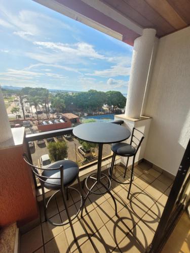 巴西利亚LAKE SIDE - BEIRA DO LAGO By Rei dos Flats的阳台配有桌椅和大窗户。