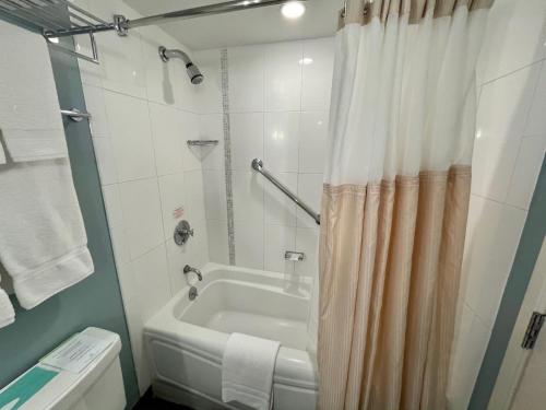 檀香山Ala Moana Hotel 31st floor的浴室配有白色的浴缸和淋浴帘