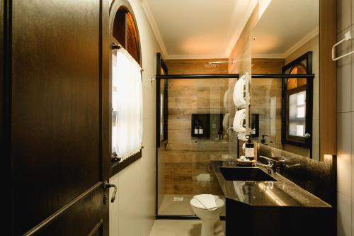 本图贡萨尔维斯Malbec Casa Hotel的一间带水槽、卫生间和淋浴的浴室