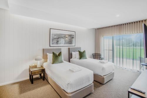 巴旺赫兹13th Beach Golf Lodges的酒店客房设有两张床和窗户。