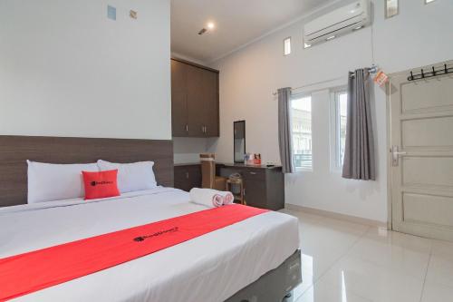 井里汶RedDoorz Plus Syariah @ Tuparev Cirebon 3的一间卧室配有一张带红色毯子的大床