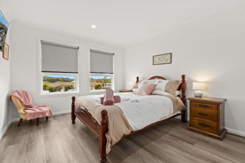 圣殿海岬Libbity's at The Point by Experience Jervis Bay的一间卧室设有一张床和两个窗户。