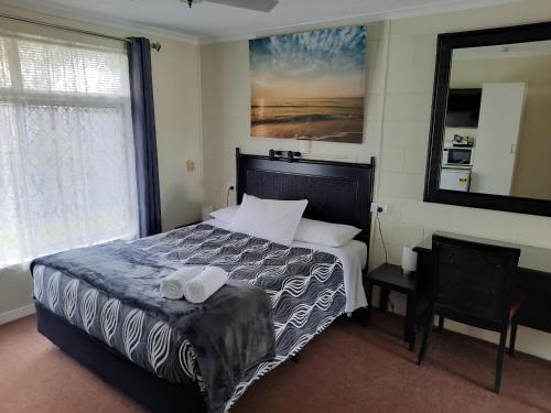 土乌巴飞翔斯普尔汽车旅馆的一间卧室配有一张床,上面有两条毛巾