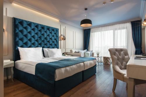 克兰内沃Casa di Fiore SPA and Medical Hotel, Mineral Pools & Private Beach的一间卧室配有一张大床和蓝色床头板