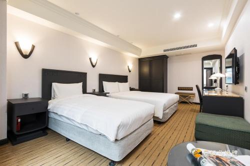 台北玩行旅大安分馆的酒店客房,设有两张床和一张沙发