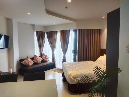 MaribagoTambuli Residence的一间卧室配有一张床和一个沙发