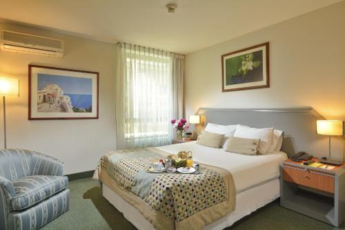 圣地亚哥埃尔博斯克欧洲酒店的配有一张床和一把椅子的酒店客房