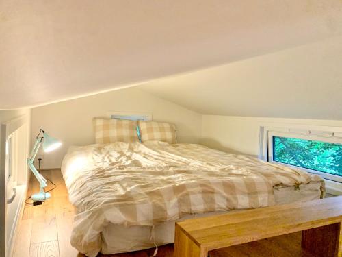 格里姆斯塔Tiny house - idyllic accommodation的一间卧室设有一张床和一个窗口