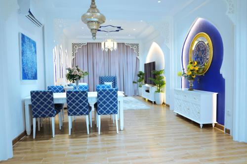 Bavet上海度假酒店的一间带桌子和蓝色椅子的用餐室