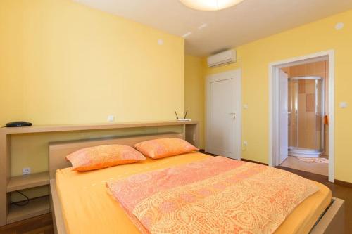 奥米沙利Villa Ajda - Orange room的一间卧室配有一张带两个枕头的床