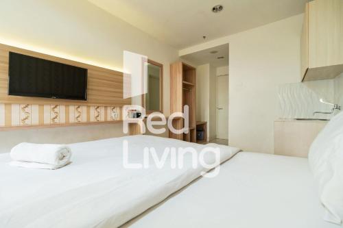 茂物RedLiving Apartemen Sentul Tower - Skyland的卧室配有白色的床和平面电视。