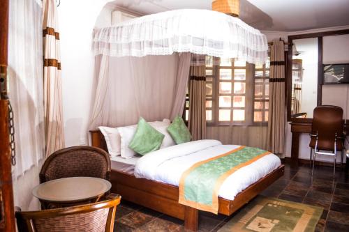 阿鲁沙Happy Rhino Lodge的一间卧室配有一张带天蓬的床