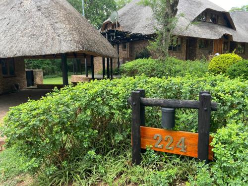 雾观Kruger Park Lodge, Kubu Lodge 224的房屋前的木凳,有标志