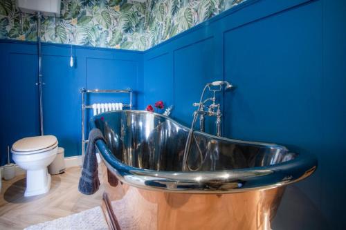 斯旺西The Langland bay look out的带浴缸的浴室拥有蓝色的墙壁和卫生间