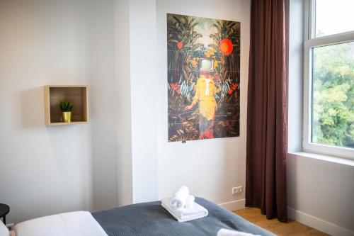 鹿特丹Spacious 2 Bedroom Serviced Apartment 77M2 -VP2B-的卧室配有一张床,墙上挂有绘画作品