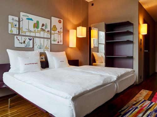 苏黎世苏黎世西区25时酒店的一间卧室配有一张带白色床单的大床