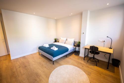鹿特丹Distinct 2 bedroom Serviced Apartment 84m2 -VP2D-的一间卧室配有蓝色的床和一张书桌