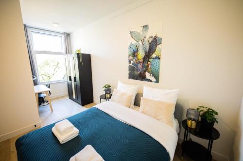 鹿特丹Dearly 1 Bedroom Serviced Apartment 56m2 -NB306D-的卧室配有蓝色和白色的床和窗户。