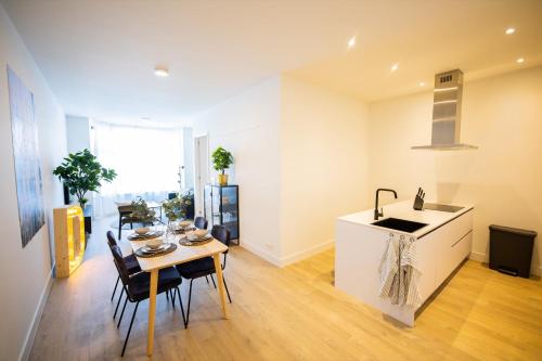 鹿特丹Dearly 1 Bedroom Serviced Apartment 56m2 -NB306D-的厨房以及带桌子和水槽的用餐室