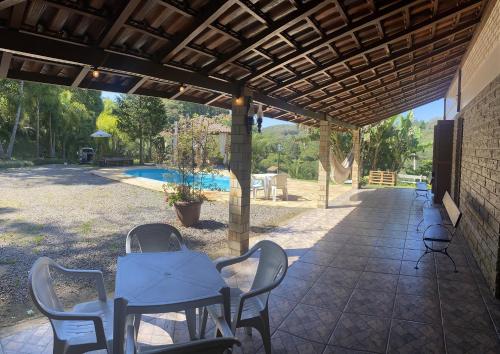 卡洛斯-巴尔博萨Sítio dos Coqueiros, em meio a natureza com piscina的一个带桌椅的庭院和一个游泳池