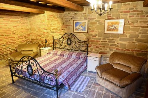 MombaroccioIl Poggio的一间卧室配有一张大床和两把椅子