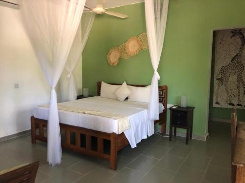 南威Kibanda Lodge and Beach Club的卧室配有白色窗帘的床