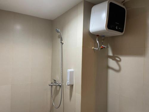 KaliastanaStay G Service Residence Jatibening的带淋浴的浴室,墙上配有电视