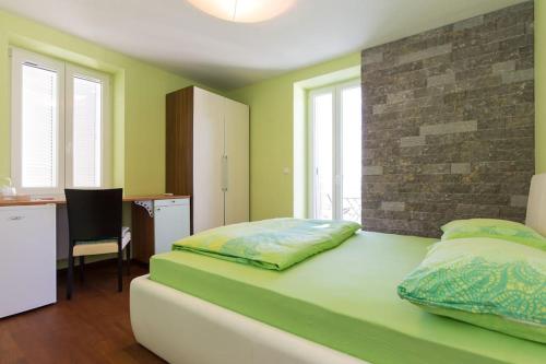 奥米沙利Villa Ajda - Green room的绿色卧室配有床和书桌