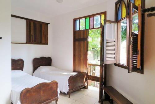 弗洛里亚诺波利斯Pousart - Floripa的一间卧室设有两张床和彩色玻璃窗。