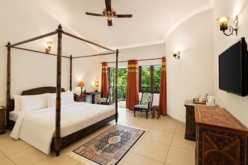 卡兰古特Storii By ITC Hotels, Shanti Morada Goa的一间卧室配有四柱床和电视。