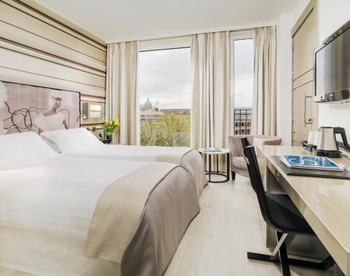 伦敦H11伦敦滑铁卢酒店的酒店客房设有一张大床和一张书桌。