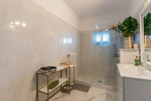 雅典Ioanna's Hellenic Hospitality的带淋浴和盥洗盆的白色浴室