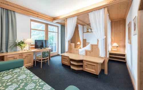 布鲁尼科费里耶微西齐健康酒店的客房设有带书桌和电视的卧室。
