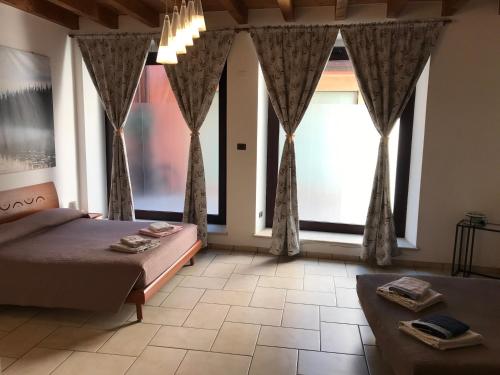 佩斯基耶拉德加达KINDLY ROBERTA centro storico Peschiera,lago relax的一间卧室设有一张床和两个大窗户