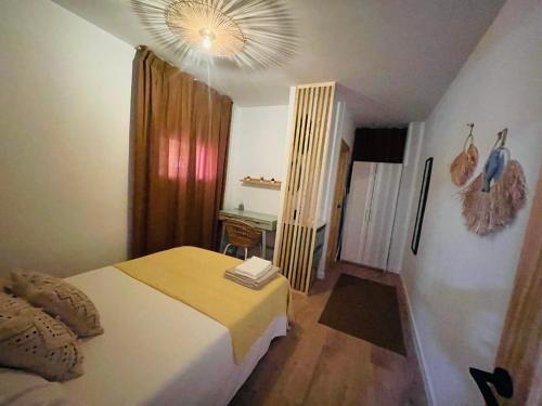 瓦伦西亚Casa del palmar junior的一间卧室配有一张床、一张桌子和一个吊灯。