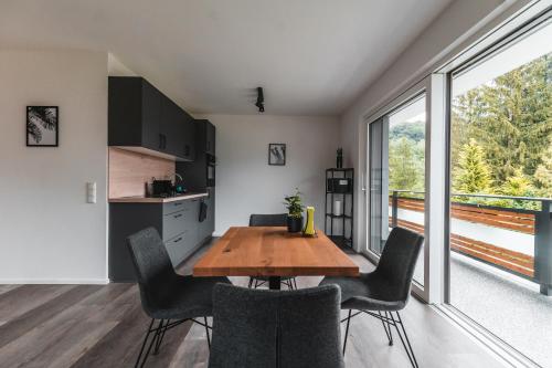 湖滨福煦Seeblick Homes的厨房以及带木桌和椅子的用餐室。