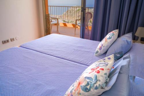 波多黎各Balcon del Mar的一间卧室配有一张蓝色床单和一个阳台。
