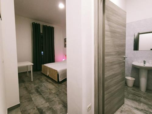 格拉索比奥Airport Boulevard Guesthouse的卧室配有床和盥洗盆