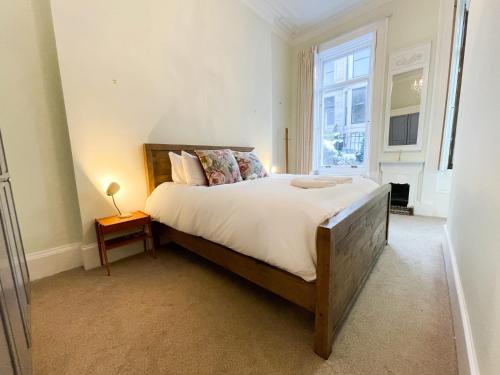 格拉斯哥1 Bed Character Filled Glasgow Apartment的一间卧室设有一张大床和一个窗户。