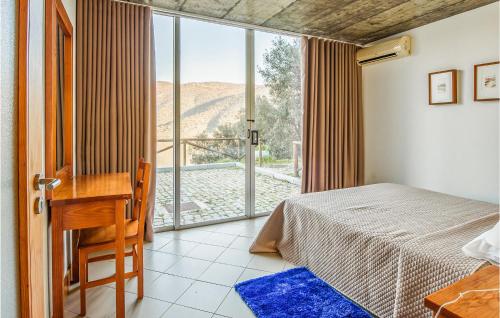 弗雷舒德埃什帕达阿辛塔Cozy Apartment In Freixo De Espada C With Outdoor Swimming Pool的一间卧室配有一张床、一张书桌和一个窗户。