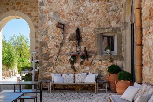 诺托I Carusi Relais的庭院内有一张石墙和沙发
