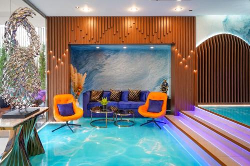曼谷曼谷美人鱼酒店的酒店大堂设有游泳池和橙色椅子