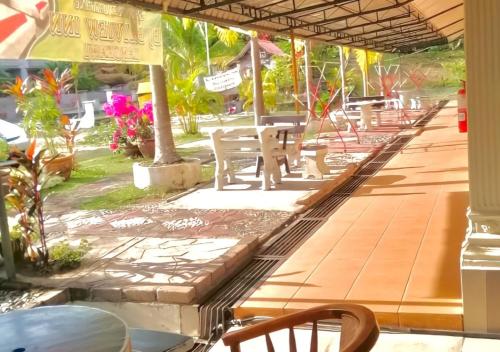 珍南海滩Kenangan Inn的餐厅内带桌椅的庭院