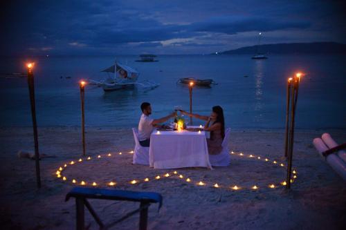 邦劳那图拉维斯塔酒店的晚坐在海滩桌子上的一对夫妇