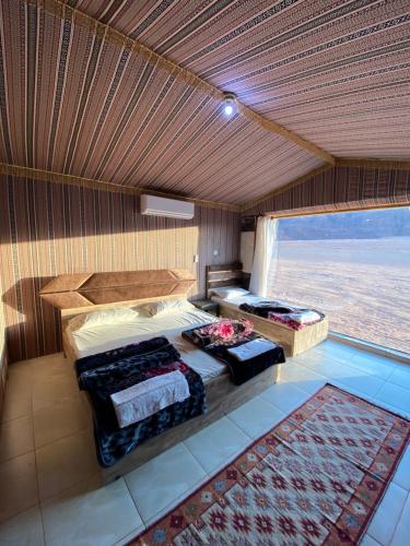 瓦迪拉姆Mountain Magic Camp Wadi Rum的一间卧室设有两张床和大窗户