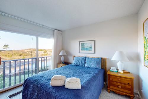 格伦阿伯Gentle Winds 9 10的一间卧室设有蓝色的床和一个阳台