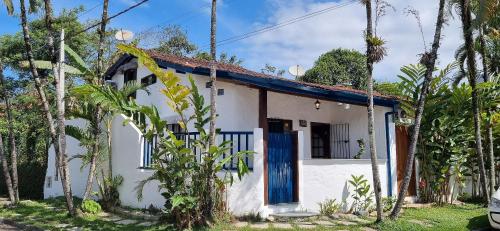 乌巴图巴Casinha D&K - Itaguá的一间白色的小房子,设有蓝色的门