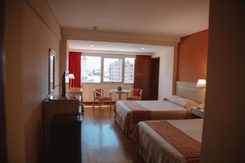 萨尔塔卡萨利尔酒店的酒店客房设有两张床和一张桌子。